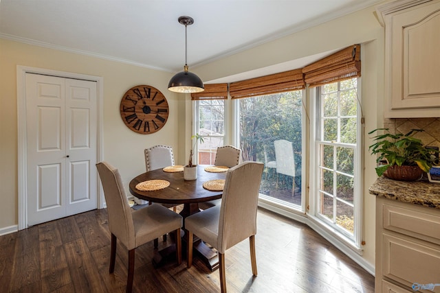 dining area featuring ornamental molding, dark wood-type flooring, and baseboards
