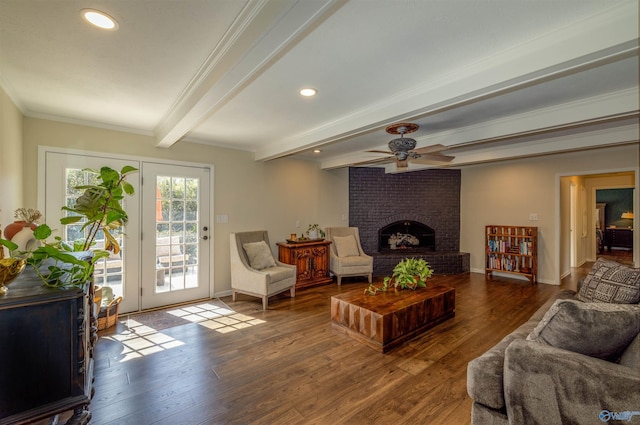 living room featuring baseboards, wood finished floors, crown molding, a fireplace, and beam ceiling