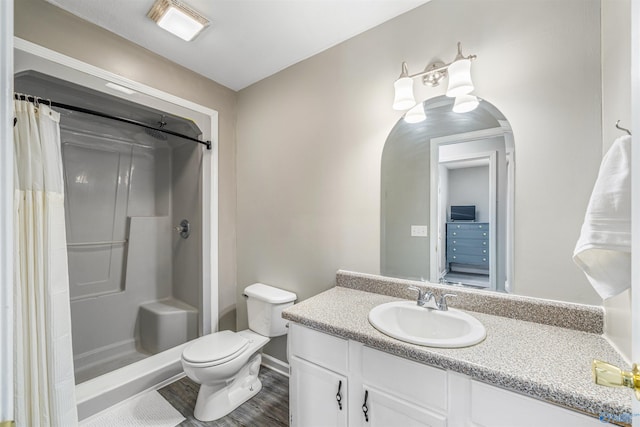 full bathroom with vanity, toilet, curtained shower, and wood finished floors