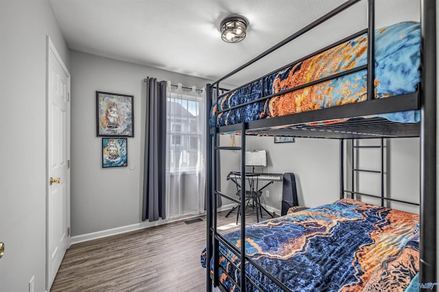 bedroom featuring baseboards, visible vents, and wood finished floors