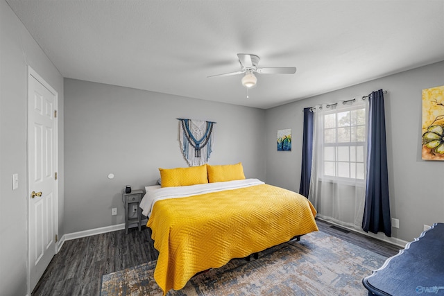 bedroom featuring baseboards, wood finished floors, and a ceiling fan