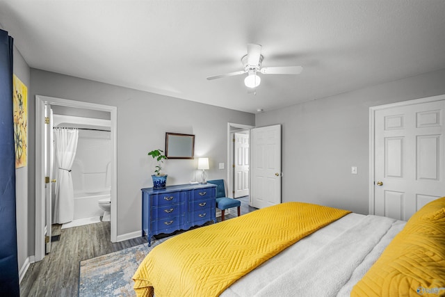 bedroom featuring a ceiling fan, dark wood-type flooring, baseboards, and connected bathroom