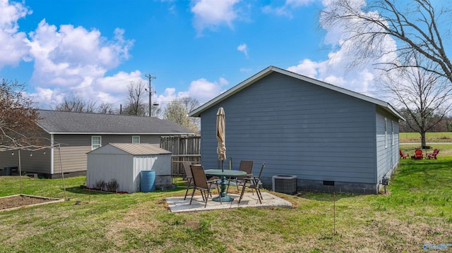 back of house with a patio area, an outdoor structure, a storage unit, crawl space, and a yard