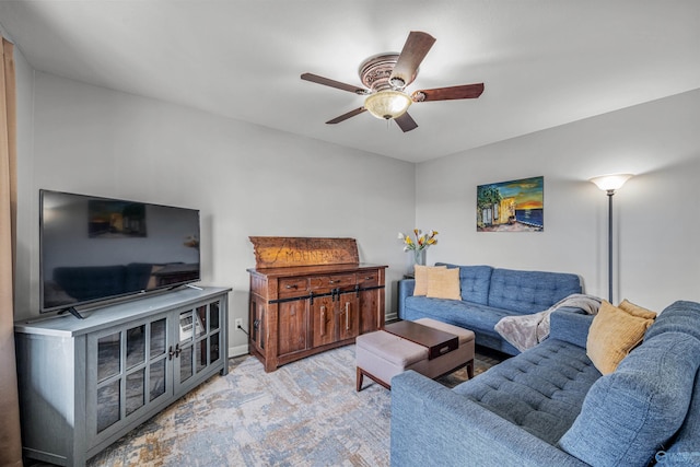 living room featuring baseboards, ceiling fan, and carpet