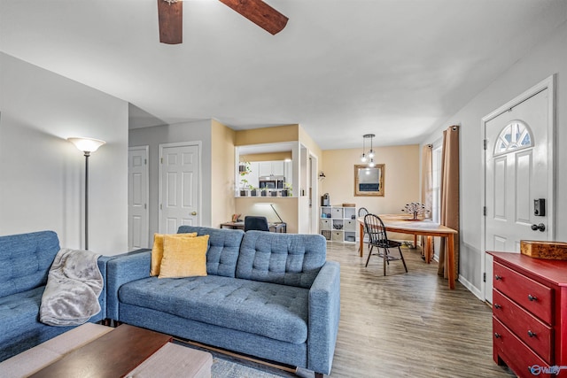 living area with wood finished floors and ceiling fan
