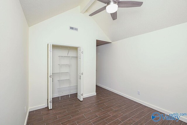 unfurnished bedroom featuring a textured ceiling, vaulted ceiling with beams, dark hardwood / wood-style flooring, a closet, and ceiling fan