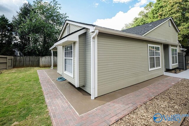 view of side of property with a lawn and a patio area