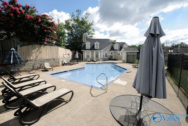 view of pool with an outbuilding and a patio area