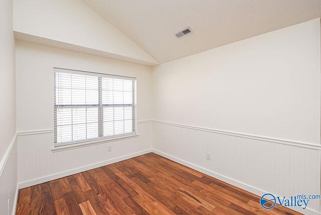 unfurnished room featuring hardwood / wood-style floors and vaulted ceiling