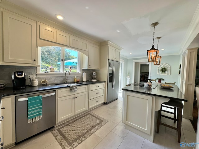 kitchen with a kitchen breakfast bar, pendant lighting, appliances with stainless steel finishes, sink, and light tile patterned flooring