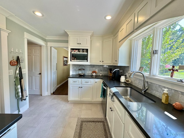 kitchen with ornamental molding, light tile patterned floors, a wealth of natural light, and sink