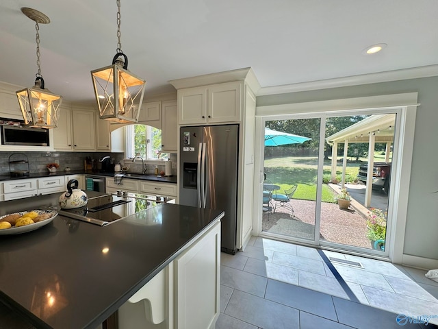 kitchen featuring hanging light fixtures, light tile patterned floors, a center island, an inviting chandelier, and stainless steel appliances