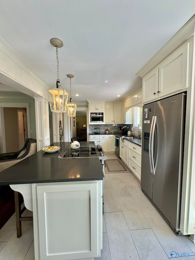 kitchen featuring appliances with stainless steel finishes, a center island, a chandelier, and decorative backsplash