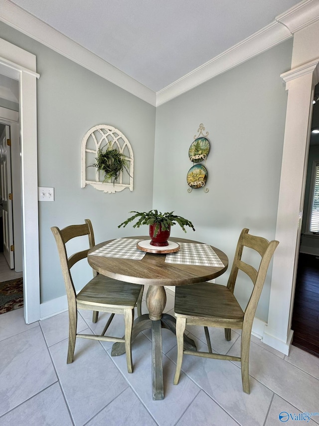 tiled dining room featuring crown molding