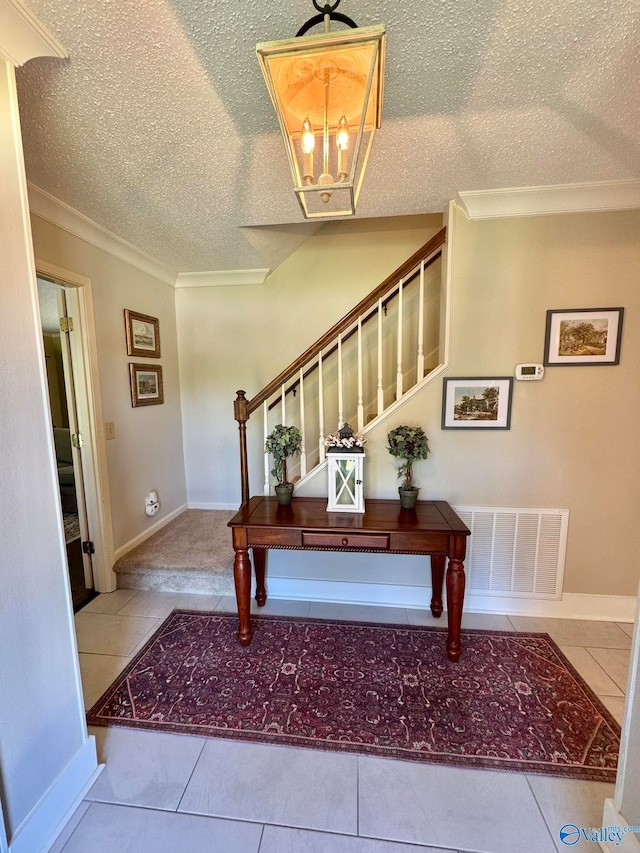 foyer with light tile patterned floors, a chandelier, and a textured ceiling