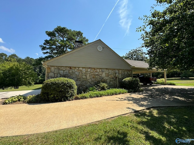 view of side of property with a lawn and a carport