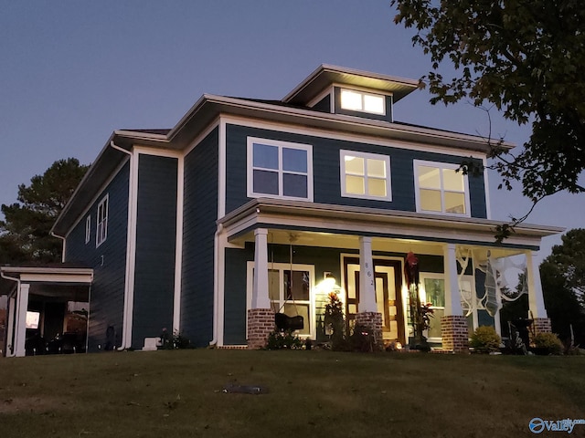 view of front of house with covered porch and a lawn