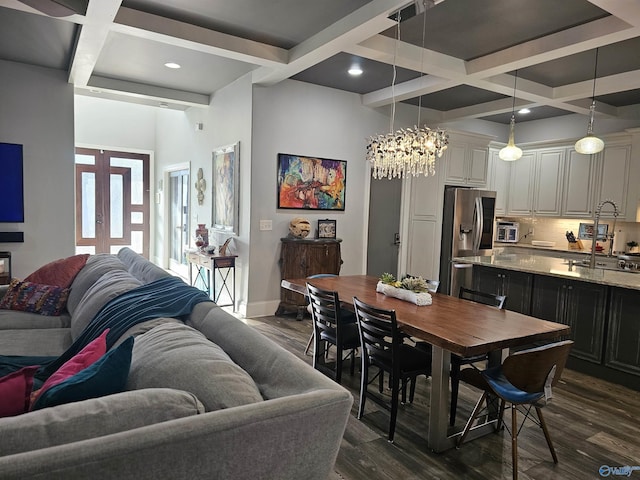 dining space featuring dark hardwood / wood-style floors, beam ceiling, coffered ceiling, an inviting chandelier, and french doors