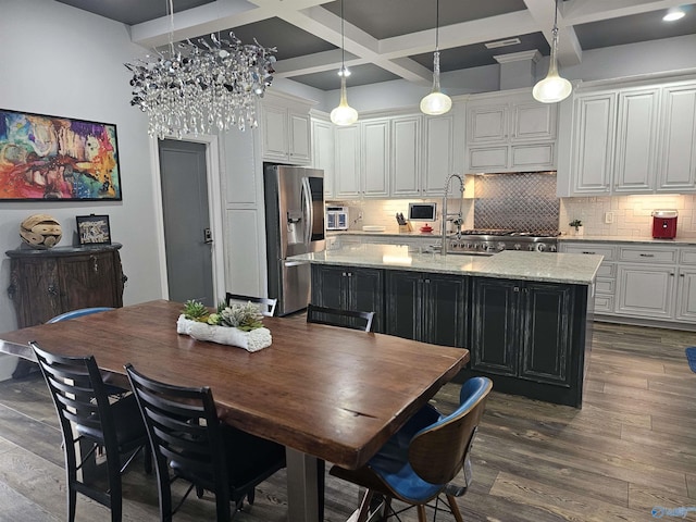 kitchen featuring coffered ceiling, a kitchen island with sink, white cabinets, and stainless steel fridge with ice dispenser