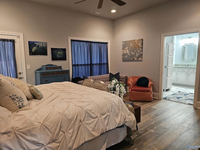 bedroom with ceiling fan, ensuite bath, sink, and dark wood-type flooring