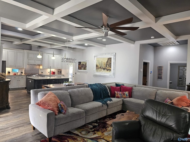 living room featuring hardwood / wood-style flooring, coffered ceiling, ceiling fan, and beam ceiling