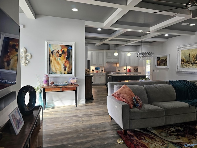 living room featuring dark wood-type flooring, coffered ceiling, and beamed ceiling