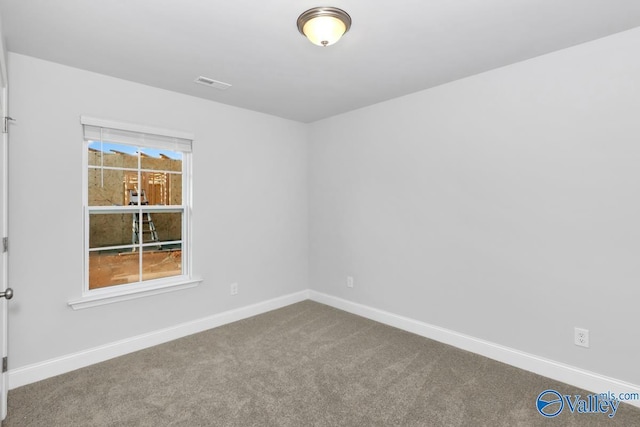 empty room featuring carpet floors, baseboards, and visible vents