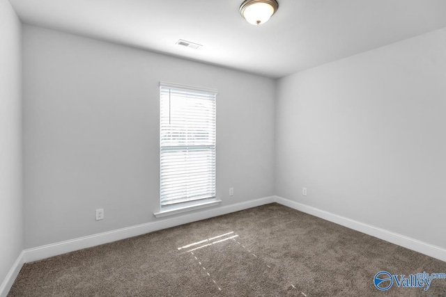 empty room featuring carpet, visible vents, and baseboards