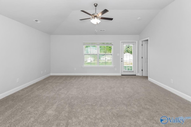 unfurnished room featuring carpet, lofted ceiling, visible vents, ceiling fan, and baseboards