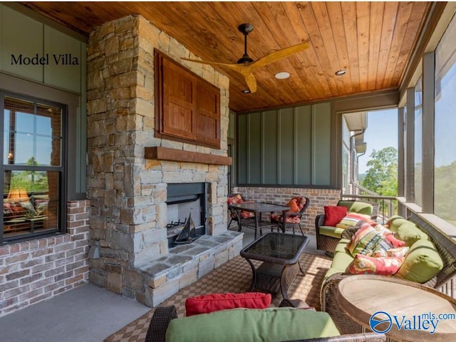 living room with ceiling fan, a stone fireplace, and wood ceiling