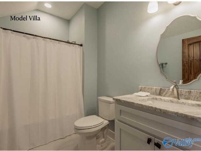 bathroom featuring vanity, toilet, tile patterned floors, and vaulted ceiling