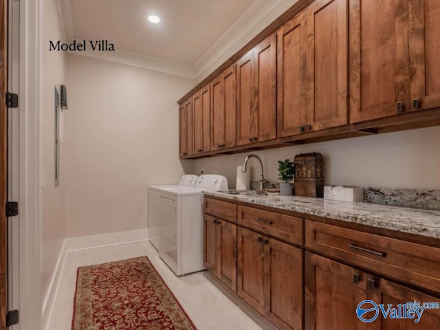 washroom featuring light tile patterned flooring, crown molding, sink, separate washer and dryer, and cabinets