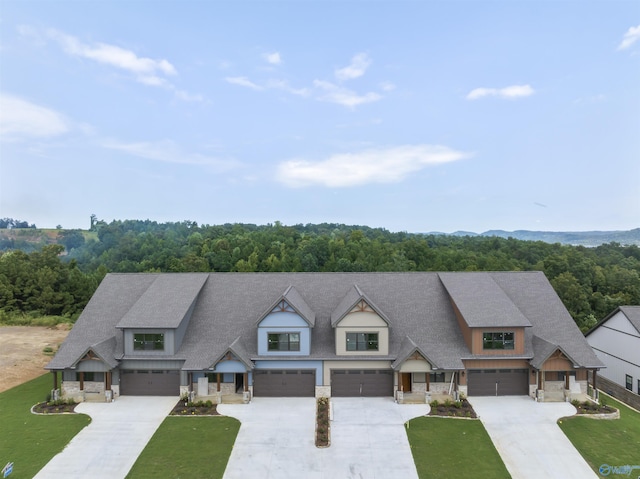 view of front of house featuring stone siding, concrete driveway, and a garage