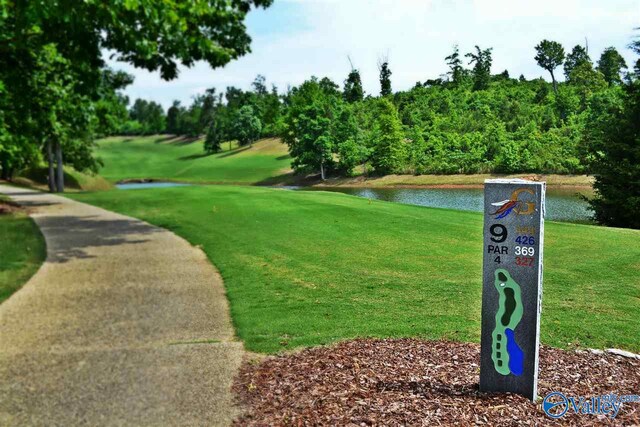 surrounding community featuring a water view and a lawn