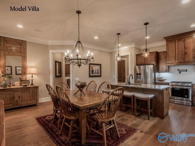 dining area with sink, an inviting chandelier, wood-type flooring, and crown molding