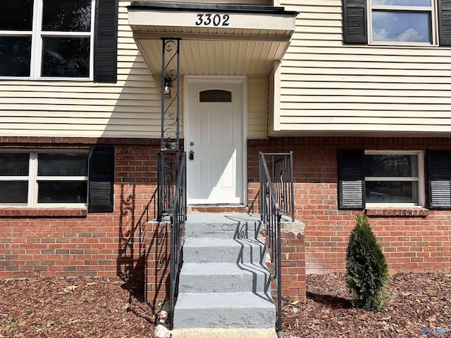 property entrance featuring brick siding