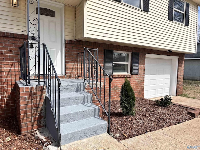 doorway to property with brick siding and a garage