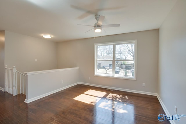 unfurnished room featuring ceiling fan, wood finished floors, visible vents, and baseboards