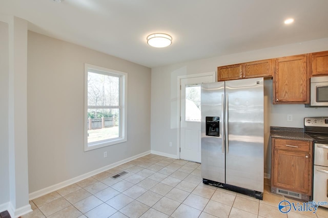 kitchen with dark countertops, a wealth of natural light, visible vents, and appliances with stainless steel finishes