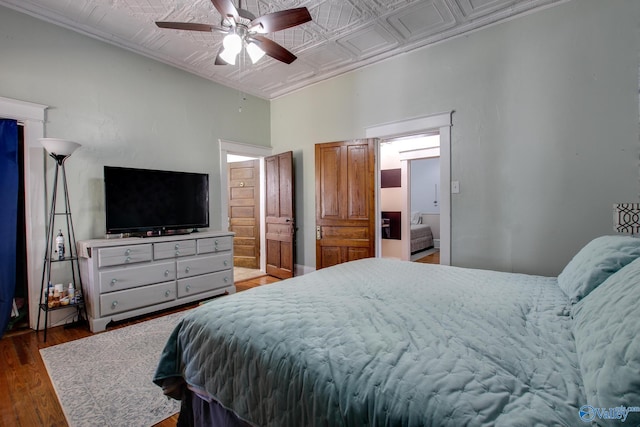 bedroom featuring ceiling fan, ensuite bathroom, and dark hardwood / wood-style flooring