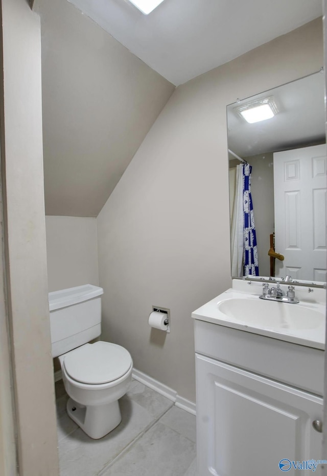 bathroom with tile patterned flooring, vanity, vaulted ceiling, toilet, and walk in shower