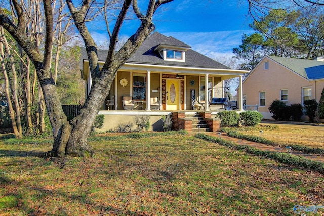 bungalow with a front yard and a porch
