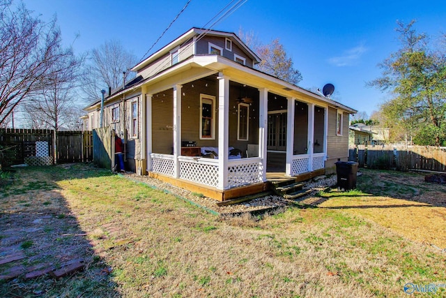 rear view of property featuring a sunroom and a lawn