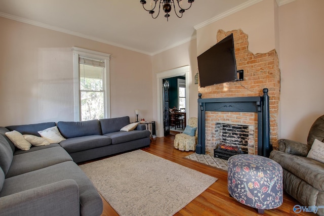 living room featuring crown molding, a brick fireplace, a healthy amount of sunlight, and hardwood / wood-style floors