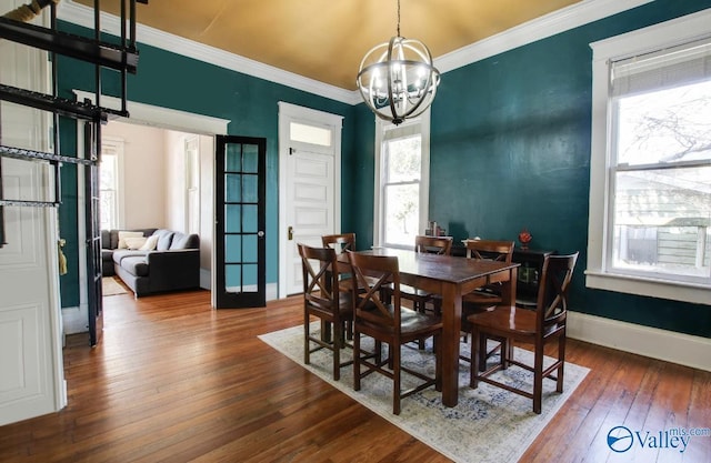 dining area featuring dark hardwood / wood-style flooring, crown molding, and an inviting chandelier