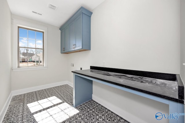 clothes washing area featuring electric dryer hookup, baseboards, cabinet space, and an office area