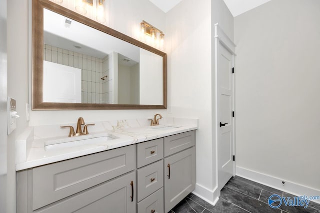full bathroom with baseboards, double vanity, and a shower