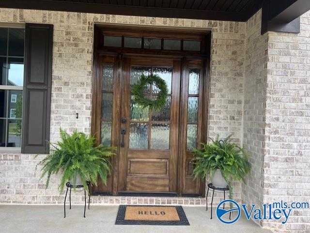 doorway to property with brick siding