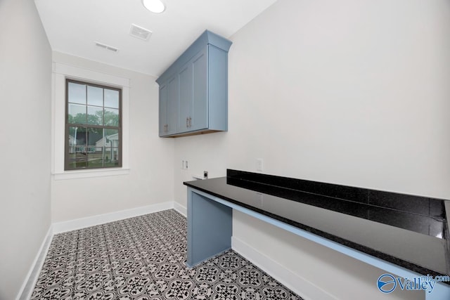 unfurnished office featuring baseboards and tile patterned floors