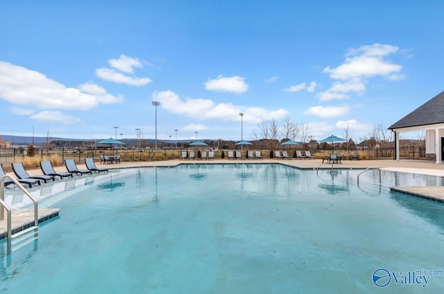 community pool with fence and a patio area